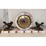 An Art Deco style marble mantle clock with circular central lock with two spelter birds on