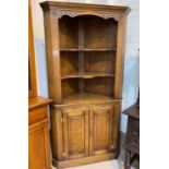 A 'Royal Oak' full height distressed oak corner cupboard with two shelves above and double