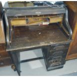 An early 20th century single pedestal desk with 'S' scroll roll top, fitted interior and 4 drawers