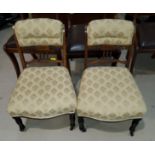 A pair of Victorian rosewood nursing chairs with carved and pierced swag decoration