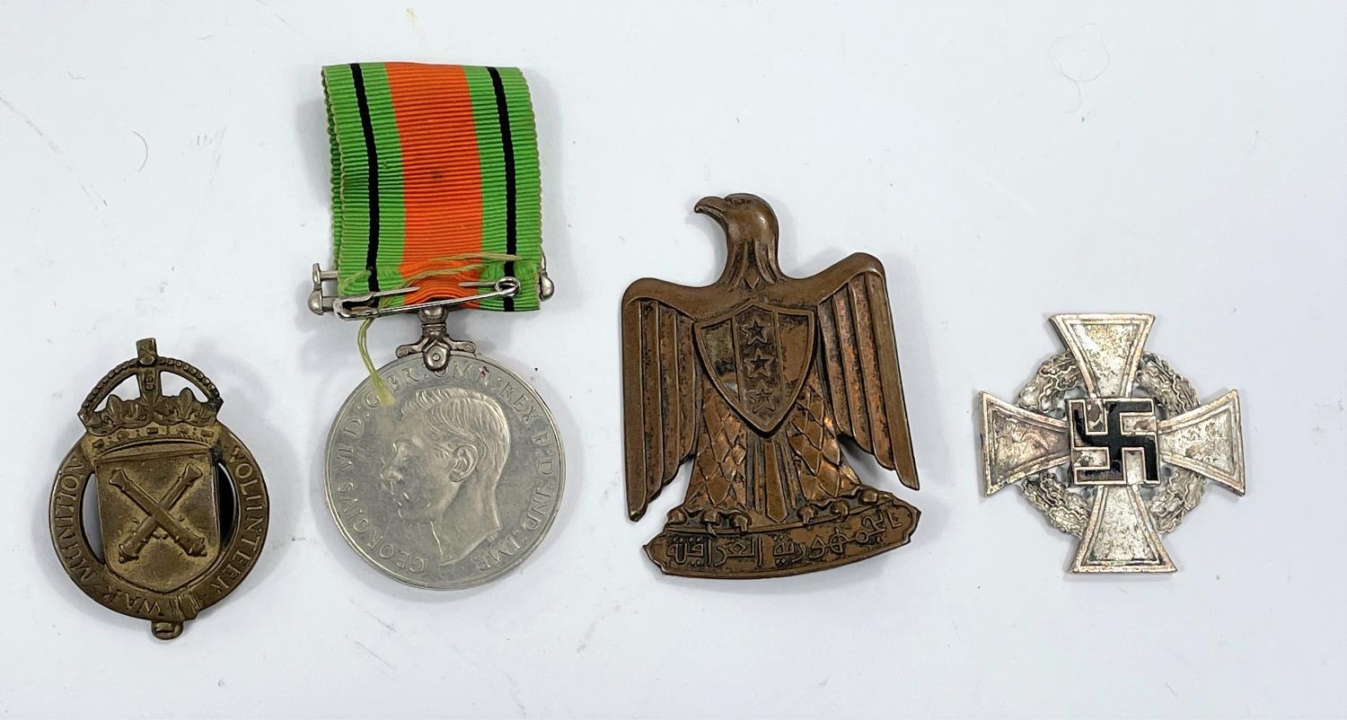 A WWII Defense medal, a War Munition Volunteer badge and 2 other items