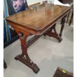 A walnut library/side table in the Arts & Crafts style with rectangular top, pierced end supports