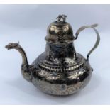 A 19th century Continental white metal teapot with domed lid, dragon spout and extensive embossed