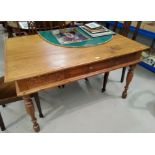 A Victorian style stripped pine kitchen table with tapered legs, carved decoration, single drawer