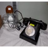 A rotary telephone in black bakelite; an 'Obsession' for men display bottle