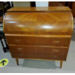 A 1970's teak cylinder bureau with pull out writing surface and 3 drawers