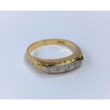 An Edwardian split shank dress ring set with 5 graduating small diamonds st. 18ct 5.5gm