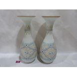 A pair of continental milchglass baluster vases, painted with flowers in diaper reserves and gilded.