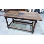 A joined oak hall table, the cleated plank top on turned and squared supports united by perimeter