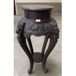 A late 19th century Chinese ebonised pot stand, the top with incised dragon, the carved overall with