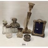 A loaded silver candlestick; a silver photograph frame; a silver napkin ring and three silver topped