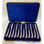 A George V cased set of cake knives and forks with loaded silver pistol grip handles for six