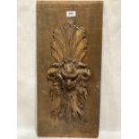 A wood panel carved with a grotesque mask in high relief. 23½' x 11'