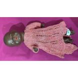 An early 20th century Armand Marseille black baby doll, the porcelain head with sleeping eyes and