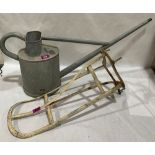 A Haws Patent vintage galvanised watering can and an iron saddle rack