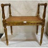 A 19th century French giltwood stool with caned seat, on fluted tapered legs. 24½' wide