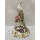 A Royal Crown Derby figure of a peafowl, standing on an urn, with applied flowers and enriched