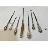 Six silver handled buttonhooks and another with horn handle