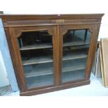 A late Victorian walnut bookcase enclosed by a pair of glazed doors