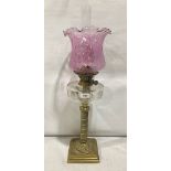 A Victorian brass oillamp with pink wrythen moulded shade and cut clear cut glass fount. 23' high.