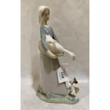 A Lladro figure of a goose girl with dog. 10¾' high