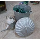 A galvanised dustbin, watering can and garden hose