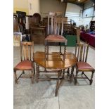 A 3'6' oak dropleaf dining table on barleytwist legs and three dining chairs