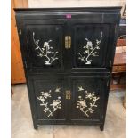 An oriental style black lacquer cabinet enclosed by two pairs of mother-of-pearl inlaid doors. 58' h