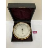 A Victorian morocco cased gilt brass aneroid barometer with silvered dial. 5¼' diam.