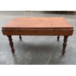 A joined pine dropleaf kitchen table on turned legs. 60' long