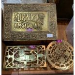 A brass embossed slipper box and two trivets