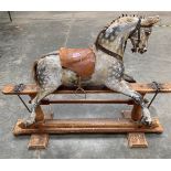 A late 19th century rocking horse on pine trestle base attributed to F.H. Ayres, with slightly