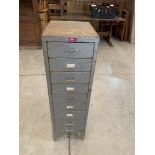 A metal filing cabinet of nine drawers. 39' high