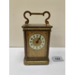 An early 20th century French brass carriage timepiece with leather carrying case. 6' high over