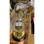 Two anniversary clocks under glass domes