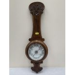 A late Victorian oak aneroid wall barometer. 35' high. Formerly with a temperature scale