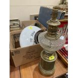 A brass table lamp in the style of an oil lamp together with a vintage glass shade