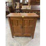 An oak cupboard enclosed by a pair of panel doors. 35' wide