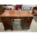 An early 20th century mahogany and burr walnut veneered kneehole desk, the leather inlet top with