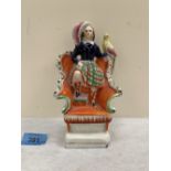 A 19th century Staffordshire group, child with bird standing on a chair 7¼' high