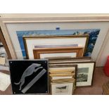 A collection of framed prints with a metal wall plaque