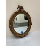 A 19th century gilt gesso oval looking glass with horse head surmount