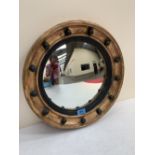 A Regency gilt wood and gesso convex looking glass with ebonised reeded slip. 16½' diam