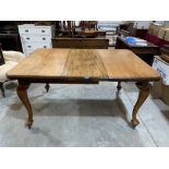 An early 20th century mahogany dining table on cabriole legs. Extends to 57½' long with one extra