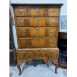 An 18th century walnut and banded chest-on-stand with three short over three long drawers, the stand