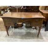 An Edward VII mahogany serpentine dressing table with four drawers, raised on tapered square legs