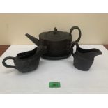 Wedgwood black basaltware. An early 19th century teapot, stand and two jugs, the example with the