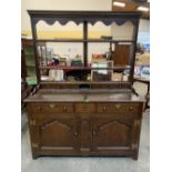 An 18th century North Wales joined oak dresser, the raised three shelf rack over four spice drawers,