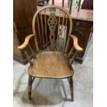 A wheelback elbow chair with elm seat on ring turned splayed legs