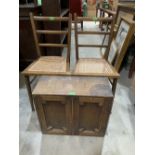 A small oak cupboard and a pair of cane seated bedroom chairs